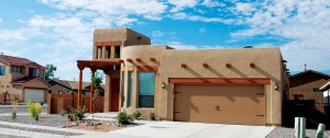 southwestern home with wide wood colored two car garage