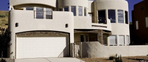 modern stucco home with wide, white garage door