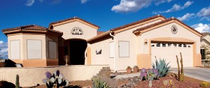 Southwestern home with desert flora and custom sun design window on garage