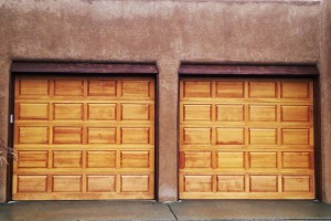 two door wood paneled garage with stucco