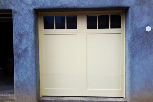 Cream single garage door with blue stucco