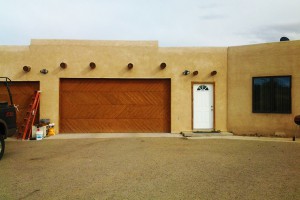 southwestern stucco stained wood paneled garage door