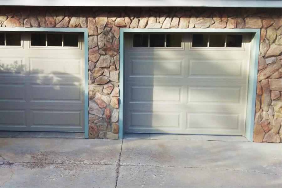 cream garage doors with windows on stone building
