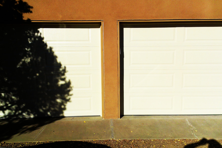 two door garage with white paneled doors
