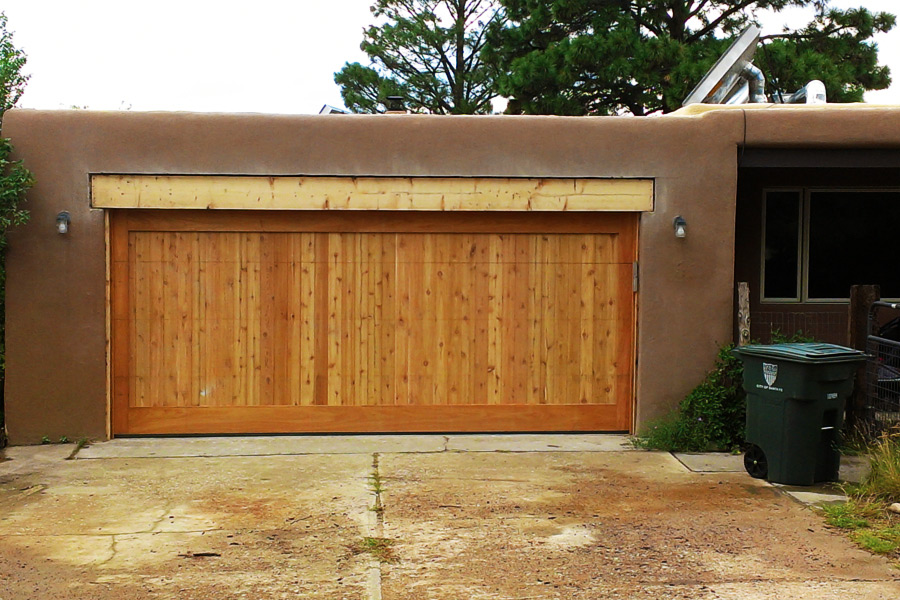 wide wooden automatic garage door on stucco building