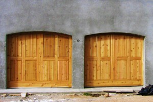 wood paneled two door garage on grey stucco